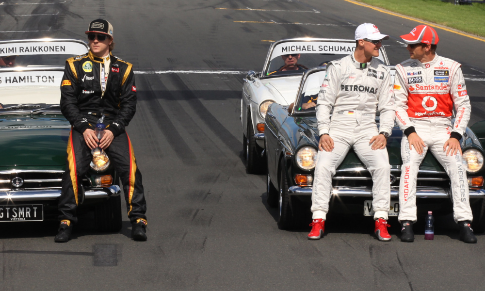 Ferrari driver Fernando Alonso, left, of Spain and Lotus driver Kimi Raikkonen of Finland wait for the drivers parade to begin as Mercedes driver Michael Schumacher of Germany and McLaren driver Jenson Button of Britain, right, chat at the Australian Formula One Grand Prix at Albert Park in Melbourne, Australia, Sunday, March 18, 2012.(AP Photo/Rob Griffith)